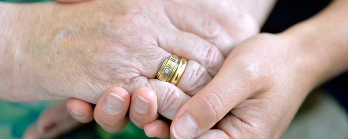 Ältere Hände halten jüngere Hände